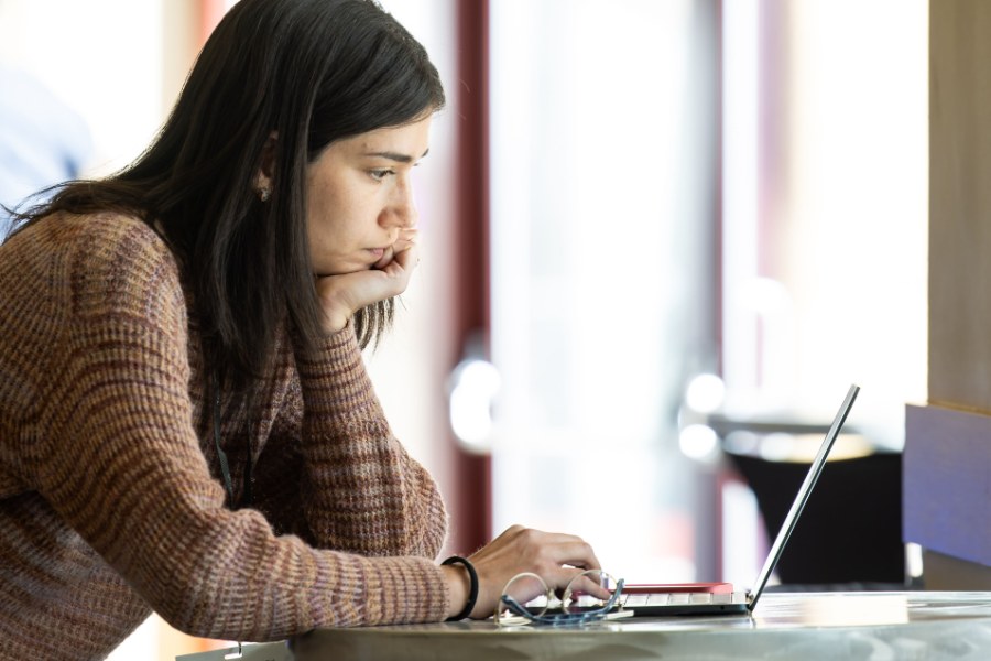 A researcher focused on her laptop at a Keystone Symposia meeting